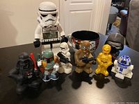 Photo showing the full set of Star Wars character figurines arranged on a table with the Stormtrooper clock in the back center.