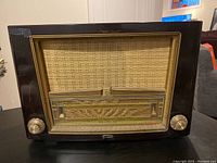 Front view of large vintage Philips vacuum tube radio showing speaker grille, tuning scale, and control knobs