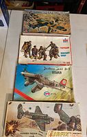 Four vintage military model kits in original boxes with box art showing military aircraft and figures.