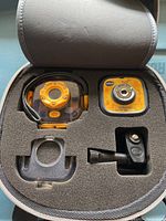 Open case showing the waterproof housing, camera, mount adapter, and remote control with foam padding