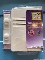 Front view of unopened, sealed Healh Zenith Wireless Doorbell Chime Kit, showing door chime speaker unit and two push buttons in clear plastic packaging with purple label.