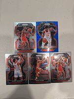 Image displaying five Atlanta Hawks basketball cards from Panini Prizm series featuring players John Collins, De'Andre Hunter, Jalek Johnson, and Trae Young.