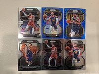 Photo showing six Denver Nuggets NBA cards featuring players Facundo Campazzo, Monte Morris, Markus Howard, and Jamal Murray in action poses on Panini Prizm card backgrounds.