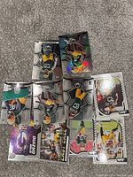 Top-down view of 8 Green Bay Packers NFL trading cards in protective sleeves laid out on carpeted floor.