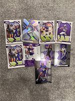 Photo showing 8 Minnesota Vikings NFL football trading cards arranged on carpet, front faces visible showing players in various football action poses and team colors