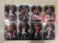 Photo showing eight New Orleans Pelicans NBA trading cards. Cards feature players Devonte' Graham, Herbert Jones, Naji Marshall (two cards), Josh Hart, and Jonas Valanciunas. Modern Panini Prizm design with black, silver, and holographic foil.