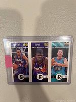 Three 1996 NBA rookie basketball cards in protective plastic sleeve; featuring players from Raptors, Suns, and Grizzlies.