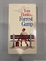 Front cover of VHS tape showing Tom Hanks sitting on bench with suitcase, movie title and tagline.