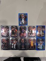 Ten Utah Jazz NBA trading cards arranged in two rows on a white surface, featuring players in various poses and card designs with blue holographic and black metallic accents.