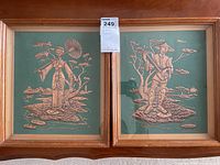 Two framed Asian wall art pieces showing a woman with a parasol and a man with a fishing pole, embossed on turquoise backgrounds.