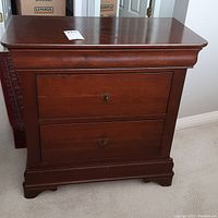 Front view of wooden nightstand showing two drawers and finish.