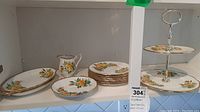 Full view of the 12-piece Royal Albert Tea Rose porcelain china set with 8 side plates, 1 creamer, and two-tier dessert tray.