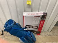 Blue Nike golf bag with attached stand and visible wear on top next to the boxed Ultimate Chipping Net