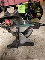Full view of Hitachi C 12 FCH miter saw showing blade housing, handle, and base with angle markings.