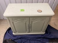 Front and top view of the off-white ornate sideboard showing split top and carved door fronts.