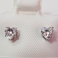 Front view of two heart-shaped cubic zirconia earrings set in white gold.