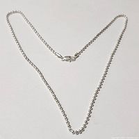 Photo of a silver beaded chain necklace measuring 20 inches with lobster claw clasp, laid out on a flat surface.