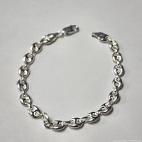 Full view of the sterling silver link chain bracelet laid flat on a gray background showing entire length and clasp.