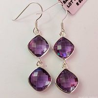 Pair of silver amethyst dangle earrings, showing two cushion-cut faceted purple amethyst stones per earring, set vertically with silver hooks.