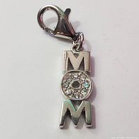 Close-up front view of silver MOM pendant charm with CZ stones
