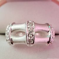 Close-up front view of silver ring focusing on double-bar design with small cubic zirconia stones embedded.