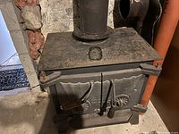 Angled front-top-side view showing overall shape, handles, hinges, and stovepipe connection.