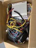 Photo showing the Clarion XA1225 4/3/2 channel amplifier with assorted wiring cables packed in a cardboard box.