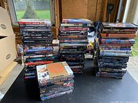 Stacked DVDs showing a wide array of movie titles and genres in their cases