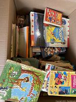 Photo of a large box filled with assorted kids books including a vintage Bambi storybook and other classic titles