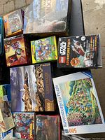 Overview of several puzzle boxes including scenic and cartoon themes arranged on the ground.