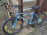Photo showing blue ECCO CCM kids bike and yellow kids bike next to wooden wall