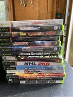 Photo showing stacked Xbox game cases with titles visible to identify the games included in the lot.