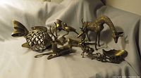 Full view showing entire collection of brass animal figurines, including giraffe, deer, koi fish, birds, and sleigh