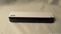 Photo of white and black compact portable Doxie Mobile Scanner showing front side and scanning slot.