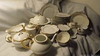 Full set arranged on cloth backdrop showing all plates, cups, saucers, serving pieces and teapot without lid