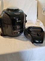 Front view of Ninja Foodi main unit with detachable lid on side.
