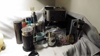 Wide view showing black espresso machine, milk frother, drink containers, and various coffee accessories on white background.
