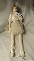 Front view of the large bisque ballerina doll laid down showing full body, clothing, and shoes