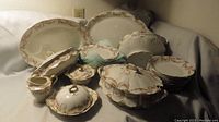 Full view of the vintage Theodore Haviland Limoges porcelain dinnerware set with pink rose garland pattern displayed on a neutral fabric background.