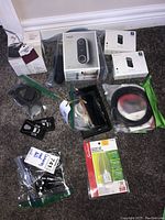 Full view of all items laid out including boxes and accessories in plastic bags on carpeted floor.