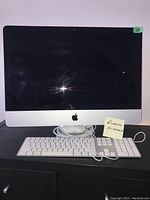 Front view of 24-inch iMac with keyboard and trackpad on desk