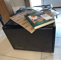 Dehydrator front view with mesh sheets and cookbook on top