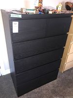 Front view of the six-drawer dresser showing the black wood finish and drawer configuration.