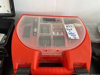 Orange Black & Decker drill case showing set of drill bits and accessories inside.