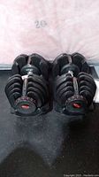 Front view of both dumbbells seated in storage stands