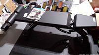 Side view of black vinyl-padded adjustable bench on metal frame