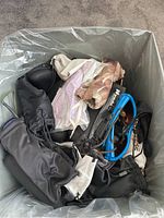 Box filled with multiple sunglasses with different frame colors and several soft protective bags.