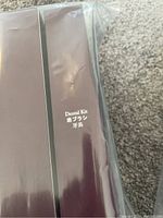 Close-up of brown box labeled 'Dental Kit' in English and Japanese, plastic wrapped.