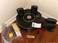 iRobot Roomba vacuum with two docking stations and a bag of accessories on floor, showing overall contents of the lot.