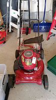 Front angle view showing handle, deck, and grass catcher bag